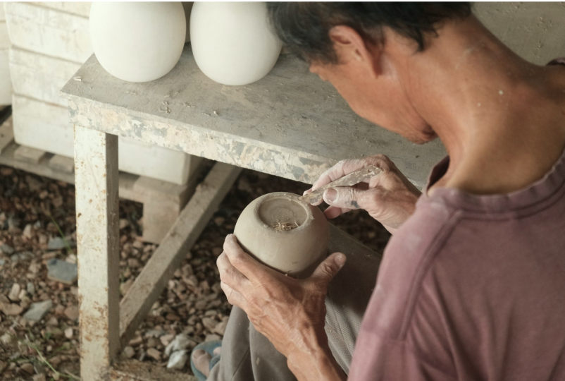 Nghệ nhân hoàn thiện sản phẩm gốm trong xưởng